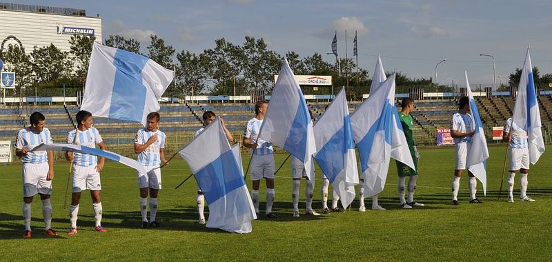 Piłkarze Stomilu Olsztyn wyszlia z flagi na środek boiska, fot. Emil Marecki